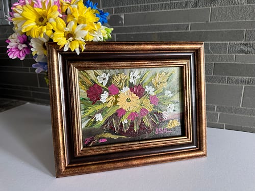A palette knife painting of pink and yellow flowers in a basket