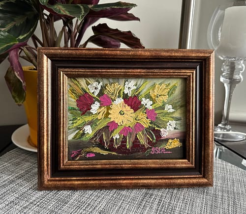 A palette knife painting of pink and yellow flowers in a basket