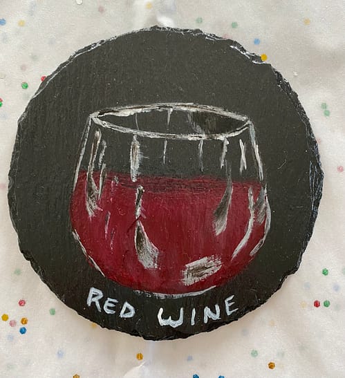 Coaster painted with a glass of red wine on it