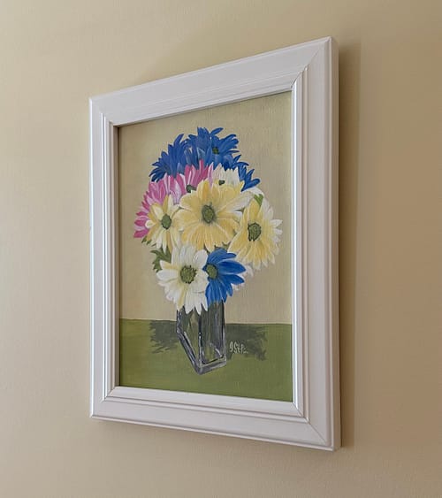 A painting of brightly coloured daisies in a clear rectangular vase