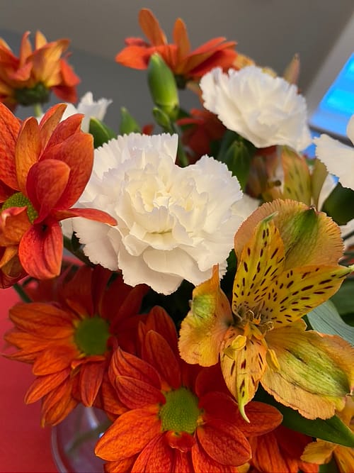 Photo of a red, orange and white flower arrangement
